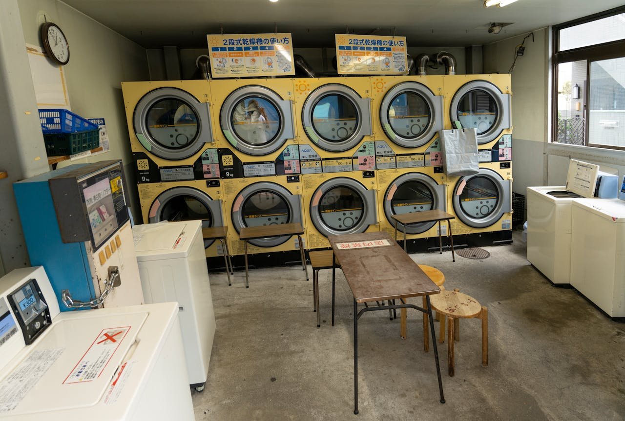 A compact laundromat in Tokyo with washing machines, dryers, and seating, showcasing urban lifestyle.